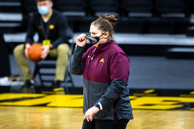 Minnesota head coach Lindsay Whalen adjusts her face mask during a NCAA Big Ten Conference women's basketball game, Wednesday, Jan. 6, 2021, at Carver-Hawkeye Arena in Iowa City, Iowa.