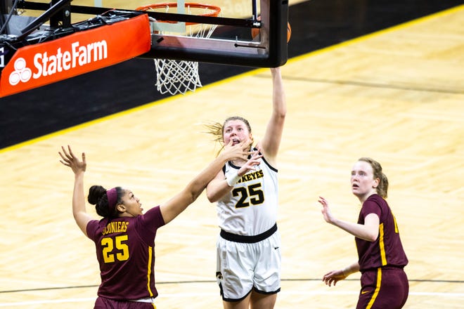 Iowa center Monika Czinano, middle, gets fouled by Minnesota center Klarke Sconiers, left, during a NCAA Big Ten Conference women's basketball game, Wednesday, Jan. 6, 2021, at Carver-Hawkeye Arena in Iowa City, Iowa.