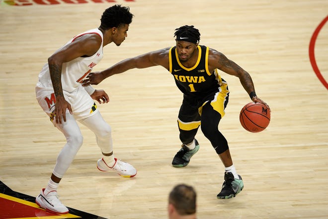 Iowa guard Joe Toussaint (1) dribbles next to Maryland guard Hakim Hart (13) during the first half of an NCAA college basketball game Jan. 7 in College Park, Maryland.