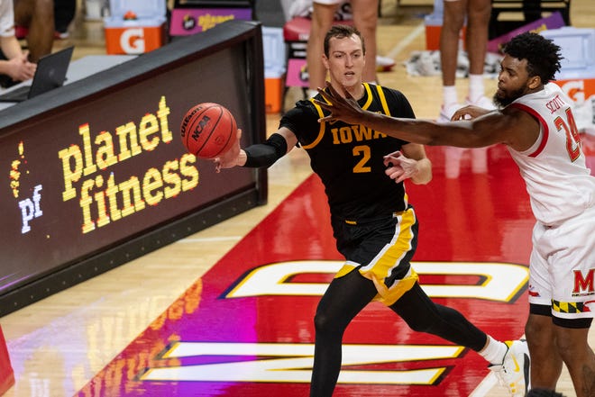 Iowa Hawkeyes forward Jack Nunge (2) passes as Maryland Terrapins forward Donta Scott (24) defends during the first half on Jan. 7 at Xfinity Center in College Park, Maryland.