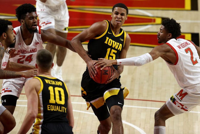 COLLEGE PARK, MARYLAND - JANUARY 07: Keegan Murray #15 of the Iowa Hawkeyes drives to the basket against Donta Scott #24 and Aaron Wiggins #2 of the Maryland Terrapins in the first half at Xfinity Center on January 07, 2021 in College Park, Maryland.