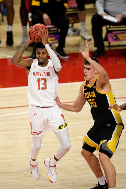 Maryland guard Hakim Hart (13) looks to pass next to Iowa center Luka Garza (55) during the first half of an NCAA college basketball game Jan. 7 in College Park, Maryland.
