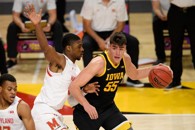 Iowa center Luka Garza (55) dribbles next to Maryland forward Jairus Hamilton, left, during the first half of an NCAA college basketball game Jan. 7 in College Park, Maryland.