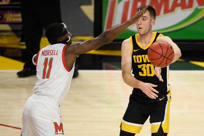 Iowa guard Connor McCaffery (30) passes the ball as he is defended by Maryland guard Darryl Morsell (11) during the first half of an NCAA college basketball game Jan. 7 in College Park, Maryland.