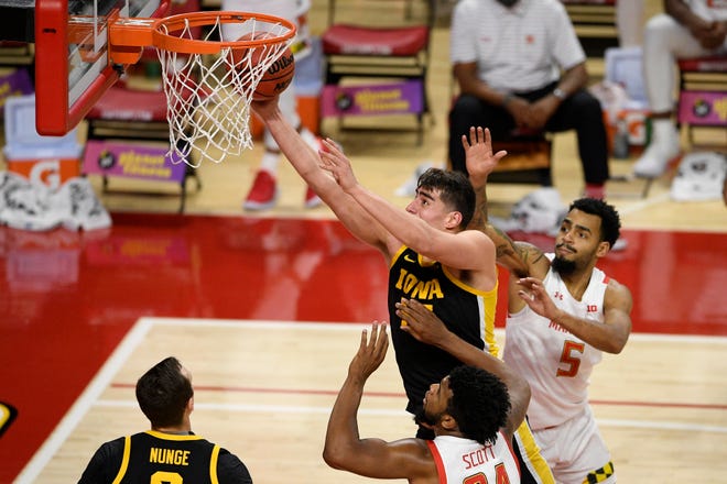 Iowa center Luka Garza, top left, goes to the basket between Maryland forward Donta Scott (24) and guard Eric Ayala (5) during the first half of an NCAA college basketball game Jan. 7 in College Park, Maryland.