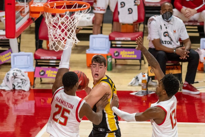 Iowa Hawkeyes center Luka Garza (55) looks too pass as Maryland Terrapins forward Jairus Hamilton (25) and guard Hakim Hart (13)  defends during the first half on Jan. 7 at Xfinity Center in College Park, Maryland.
