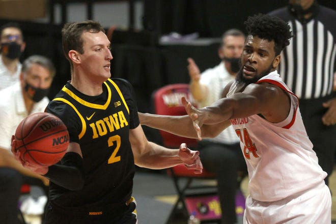 COLLEGE PARK, MARYLAND - JANUARY 07: Jack Nunge #2 of the Iowa Hawkeyes passes around Donta Scott #24 of the Maryland Terrapins in the first half at Xfinity Center on January 07, 2021 in College Park, Maryland.