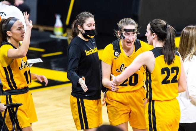 Iowa guard Caitlin Clark (22) gets greeted by teammates, from left, Megan Meyer, Lauren Jensen and Kate Martin heading into a timeout during a NCAA Big Ten Conference women's basketball game against Ohio State, Wednesday, Jan. 13, 2021, at Carver-Hawkeye Arena in Iowa City, Iowa.