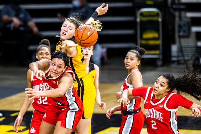 Iowa center Monika Czinano fights for a rebound against Ohio State guard Braxtin Miller, left, as Ohio State forward Gabby Hutcherson (2) defends in overtime during a NCAA Big Ten Conference women's basketball game, Wednesday, Jan. 13, 2021, at Carver-Hawkeye Arena in Iowa City, Iowa.