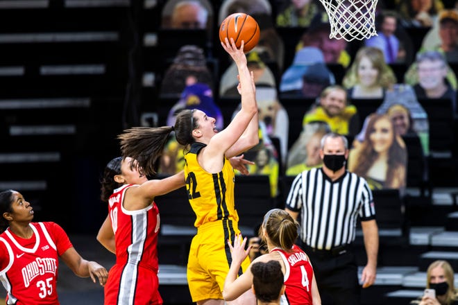 Iowa guard Caitlin Clark (22) makes a basket as Ohio State forward Tanaya Beacham (35) Ohio State guards Braxtin Miller, left, and Jacy Sheldon (4) defend during a NCAA Big Ten Conference women's basketball game, Wednesday, Jan. 13, 2021, at Carver-Hawkeye Arena in Iowa City, Iowa.