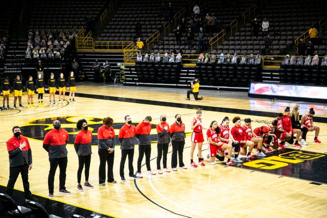 Members of the Ohio State Buckeyes kneel as the national anthem is played before a NCAA Big Ten Conference women's basketball game against the Iowa Hawkeyes, Wednesday, Jan. 13, 2021, at Carver-Hawkeye Arena in Iowa City, Iowa.