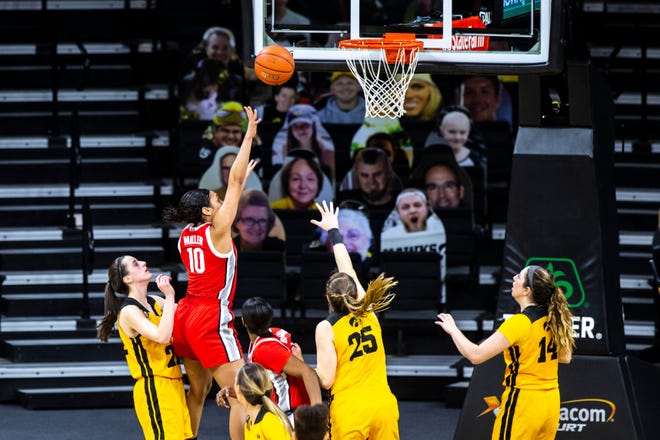 Ohio State guard Braxtin Miller (10) makes a basket as Iowa guard Caitlin Clark, left, and Iowa center Monika Czinano (25) defend during a NCAA Big Ten Conference women's basketball game, Wednesday, Jan. 13, 2021, at Carver-Hawkeye Arena in Iowa City, Iowa.
