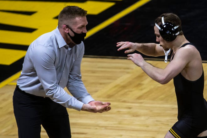 Iowa's Spencer Lee gets a high-five from Iowa assistant coach Ryan Morningstar while running off the mat after wrestling at 125 pounds during a NCAA Big Ten Conference wrestling dual against Nebraska, Friday, Jan. 15, 2021, at Carver-Hawkeye Arena in Iowa City, Iowa.