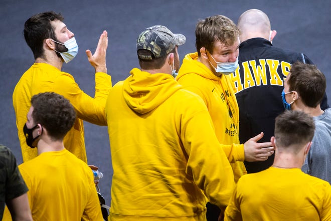 Iowa wrestler Jaydin Eierman, top left, blows a kiss to the Nebraska Cornhuskers after the Hawkeyes' 31-6, victory, as teammates Nelson Brands and Spencer Lee discuss their win during a NCAA Big Ten Conference wrestling dual, Friday, Jan. 15, 2021, at Carver-Hawkeye Arena in Iowa City, Iowa.