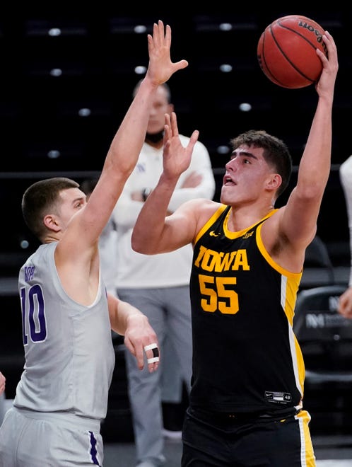 Iowa center Luka Garza, right, shoots against Northwestern forward Miller Kopp during the first half of an NCAA college basketball game in Evanston, Ill., Sunday, Jan. 17, 2021. (AP Photo/Nam Y. Huh)
