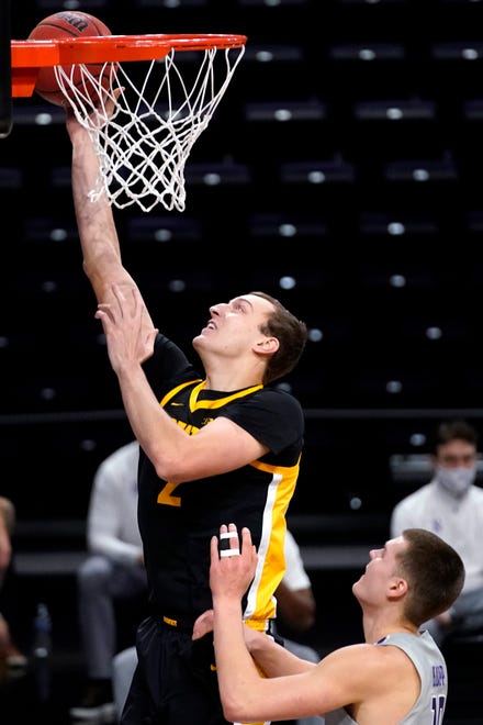 Iowa forward Jack Nunge, left, drives to the basket past Northwestern forward Miller Kopp during the first half of an NCAA college basketball game in Evanston, Ill., Sunday, Jan. 17, 2021. (AP Photo/Nam Y. Huh)