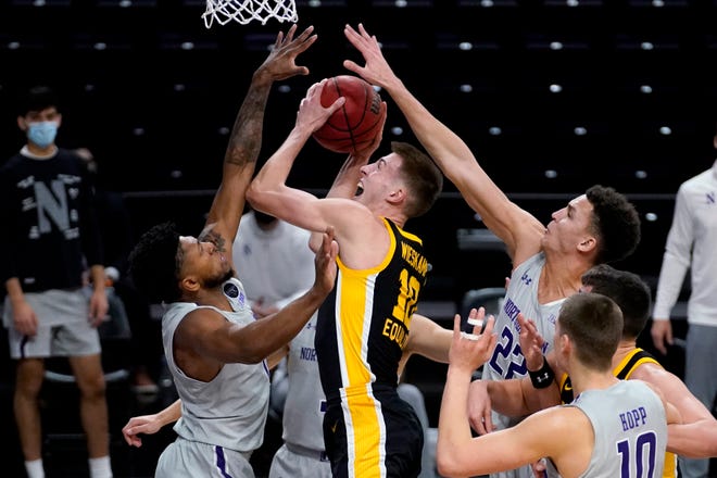 Iowa guard/forward Joe Wieskamp, center, goes up for a shot between Northwestern guard Anthony Gaines, left, and forward Pete Nance during the first half of an NCAA college basketball game in Evanston, Ill., Sunday, Jan. 17, 2021. (AP Photo/Nam Y. Huh)