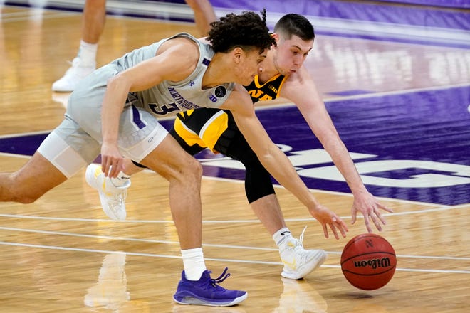 Northwestern guard Ty Berry, left, and Iowa guard CJ Fredrick battle for a loose ball during the first half of an NCAA college basketball game in Evanston, Ill., Sunday, Jan. 17, 2021. (AP Photo/Nam Y. Huh)