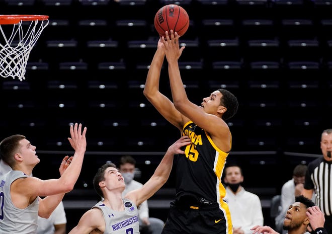 Iowa forward Keegan Murray, center, goes up for a shot against Northwestern during the first half of an NCAA college basketball game in Evanston, Ill., Sunday, Jan. 17, 2021. (AP Photo/Nam Y. Huh)