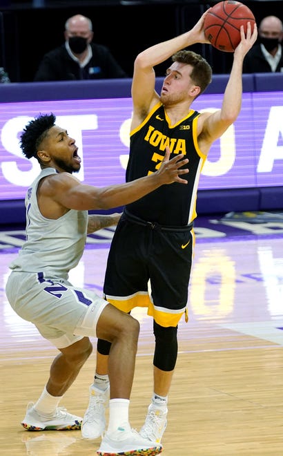 Iowa guard Jordan Bohannon, right, looks to pass as Northwestern guard Anthony Gaines guards during the first half of an NCAA college basketball game in Evanston, Ill., Sunday, Jan. 17, 2021. (AP Photo/Nam Y. Huh)