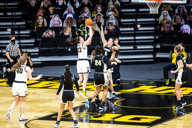 Iowa guard Caitlin Clark (22) attempts a basket as Purdue guard Cassidy Hardin (5) and Purdue center Ra Shaya Kyle (24) defend during a NCAA Big Ten Conference women's basketball game, Monday, Jan. 18, 2021, at Carver-Hawkeye Arena in Iowa City, Iowa.