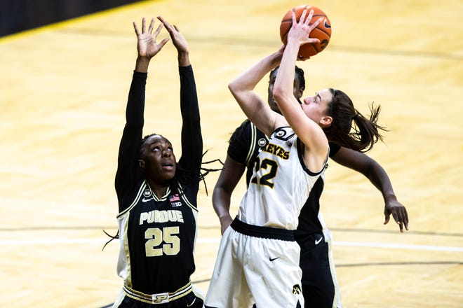 Iowa guard Caitlin Clark (22) makes a basket as Purdue's Tamara Farquhar (25) and Purdue center Fatou Diagne, behind, defend during a NCAA Big Ten Conference women's basketball game, Monday, Jan. 18, 2021, at Carver-Hawkeye Arena in Iowa City, Iowa.