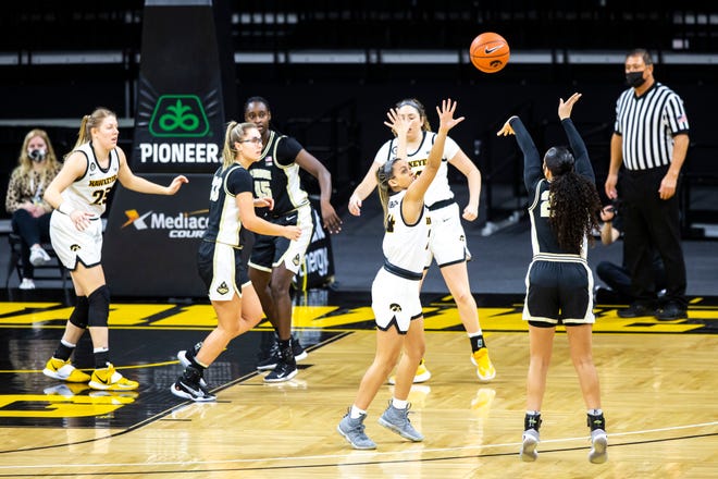 Purdue guard Kayana Traylor, right, makes a 3-point basket as Iowa guard Gabbie Marshall defends during a NCAA Big Ten Conference women's basketball game, Monday, Jan. 18, 2021, at Carver-Hawkeye Arena in Iowa City, Iowa.