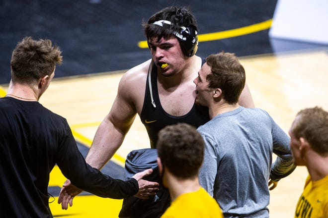 Iowa's Tony Cassioppi, middle, celebrates with teammates Max Murin, left, and Spencer Lee after scoring a fall at 285 pounds during a NCAA Big Ten Conference wrestling dual against the Illinois Fighting Illini, Sunday, Jan. 31, 2021, at Carver-Hawkeye Arena in Iowa City, Iowa.