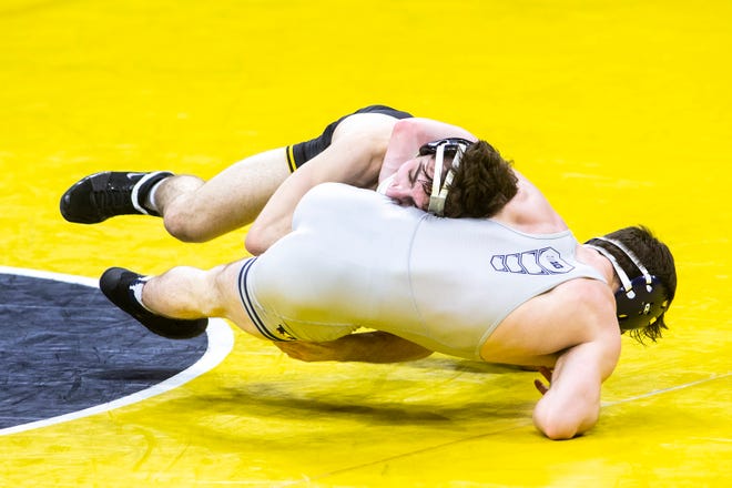 Iowa's Austin DeSanto, left, scores a takedown on Illinois' Lucas Byrd at 133 pounds during a NCAA Big Ten Conference wrestling dual, Sunday, Jan. 31, 2021, at Carver-Hawkeye Arena in Iowa City, Iowa.
