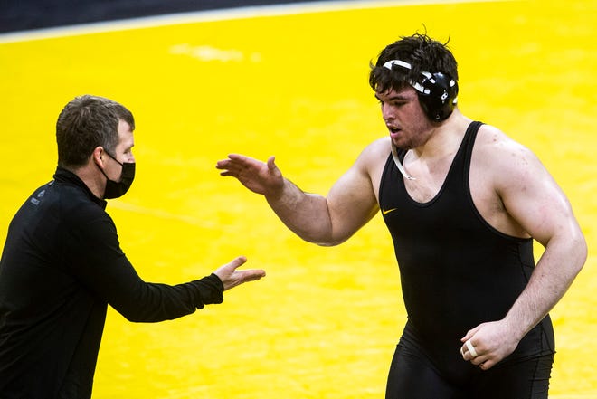 Iowa's Tony Cassioppi, right, celebrates with Iowa head coach Tom Brands after scoring a fall at 285 pounds during a NCAA Big Ten Conference wrestling dual against the Illinois Fighting Illini, Sunday, Jan. 31, 2021, at Carver-Hawkeye Arena in Iowa City, Iowa.