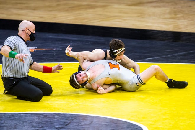 Iowa's Austin DeSanto, top, scores a takedown on Illinois' Lucas Byrd at 133 pounds during a NCAA Big Ten Conference wrestling dual, Sunday, Jan. 31, 2021, at Carver-Hawkeye Arena in Iowa City, Iowa.