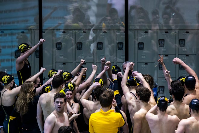 Iowa Hawkeyes women's and men's swimmers huddle up around head coach Marc Long during a NCAA Big Ten Conference swimming and diving meet, Saturday, Jan. 16, 2021, at the Campus Recreation and Wellness Center on the University of Iowa campus in Iowa City, Iowa.