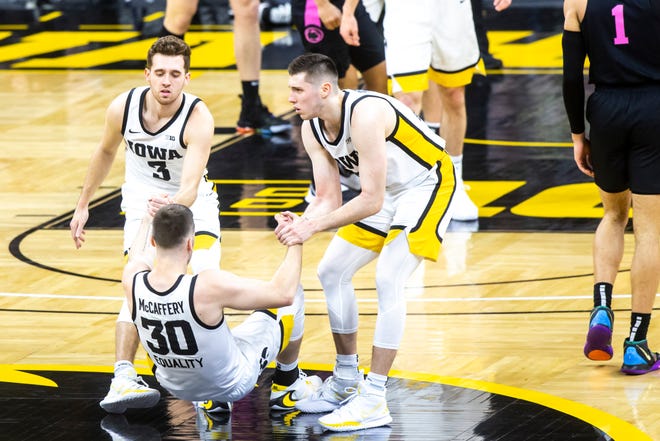Iowa's Connor McCaffery (30) gets helped up by teammates Iowa guard Jordan Bohannon (3) and Iowa guard CJ Fredrick (5) during a NCAA Big Ten Conference men's basketball game against Penn State, Sunday, Feb. 21, 2021, at Carver-Hawkeye Arena in Iowa City, Iowa.