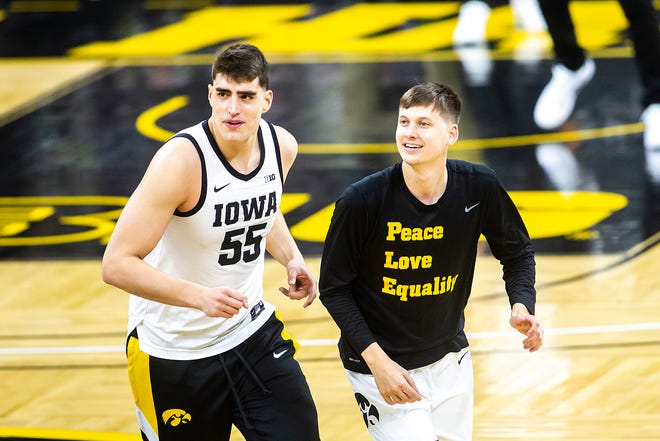 Iowa center Luka Garza (55) and guard Austin Ash run to the locker room after warmups before a NCAA Big Ten Conference men's basketball game against Penn State, Sunday, Feb. 21, 2021, at Carver-Hawkeye Arena in Iowa City, Iowa.