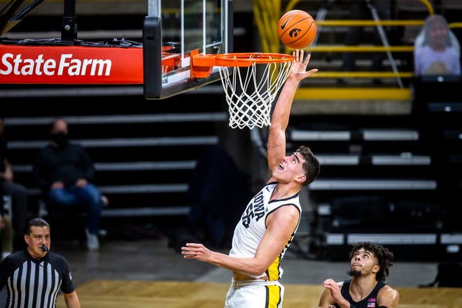 Iowa center Luka Garza (55) makes a basket as Penn State forward Seth Lundy (1) defends during a NCAA Big Ten Conference men's basketball game, Sunday, Feb. 21, 2021, at Carver-Hawkeye Arena in Iowa City, Iowa. The basket set the new Iowa Hawkeyes all-time scoring record.