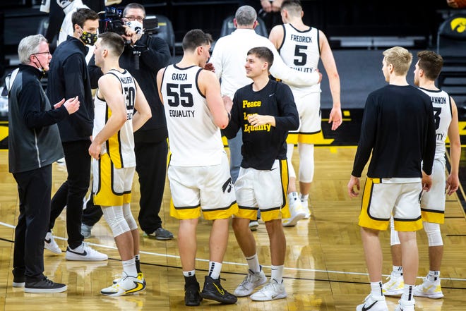 Iowa center Luka Garza (55) is greeted by teammate Austin Ash (13) after a NCAA Big Ten Conference men's basketball game against Penn State, Sunday, Feb. 21, 2021, at Carver-Hawkeye Arena in Iowa City, Iowa.