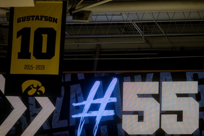 The number 55 is shown on a video board during a presentation after Iowa center Luka Garza set the men's basketball scoring record, seen next to banner of Iowa Hawkeyes center Megan Gustafson in the rafters, Sunday, Feb. 21, 2021, at Carver-Hawkeye Arena in Iowa City, Iowa. Gustafson leads the women's program with 2,804 points. Garza surpassed 2,118 during the Hawkeyes' game against Penn State, to become the new leader in the men's record book.