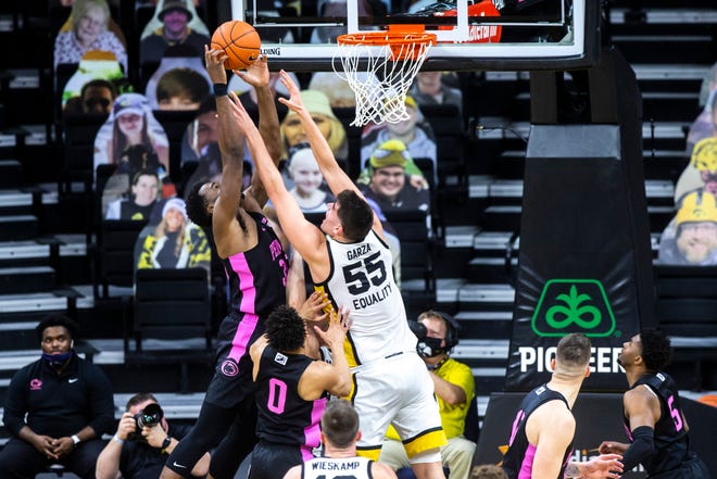 Penn State forward Abdou Tsimbila, left, goes up to the rim against Iowa center Luka Garza (55) as Penn State guard Myreon Jones (0) defends during a NCAA Big Ten Conference men's basketball game, Sunday, Feb. 21, 2021, at Carver-Hawkeye Arena in Iowa City, Iowa.