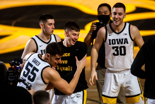 Iowa center Luka Garza (55) grabs teammate Austin Ash  during introductions before a NCAA Big Ten Conference men's basketball game against Penn State, Sunday, Feb. 21, 2021, at Carver-Hawkeye Arena in Iowa City, Iowa.