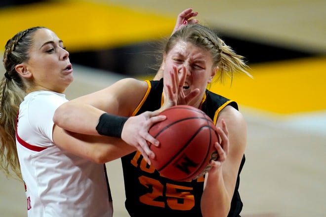 Iowa forward Monika Czinano (25) and Maryland guard Faith Masonius compete for a rebound during the first half of an NCAA college basketball game, Tuesday, Feb. 23, 2021, in College Park, Md.