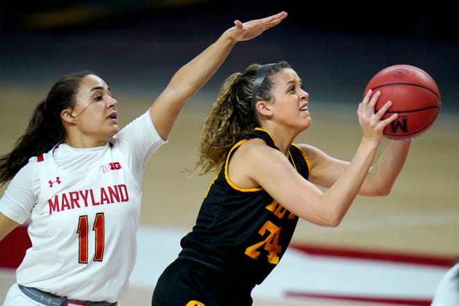 Iowa guard Gabbie Marshall, right, shoots a basket against Maryland guard Katie Benzan during the first half of an NCAA college basketball game, Tuesday, Feb. 23, 2021, in College Park, Md.