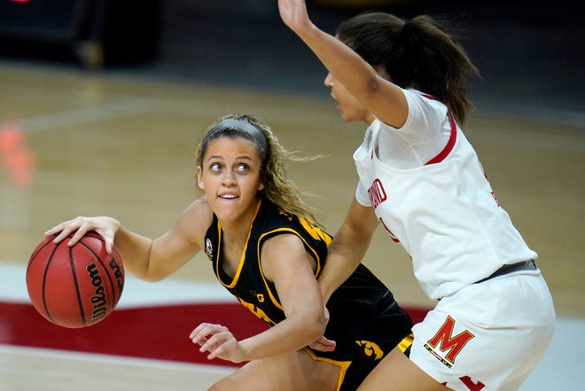 Iowa guard Gabbie Marshall, left, works the floor against Maryland guard Katie Benzan during the first half of an NCAA college basketball game, Tuesday, Feb. 23, 2021, in College Park, Md.