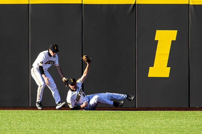 Iowa center fielder Ben Norman (9) holds up his glove after grabbing an out as teammate Sam Link, left, reacts during a NCAA Big Ten Conference baseball game against Nebraska, Friday, March 19, 2021, at Duane Banks Field in Iowa City, Iowa.