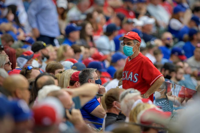 A view of a fan wearing a mask during the fifth inning of the game between the Rangers and Blue Jays at Globe Life Field.