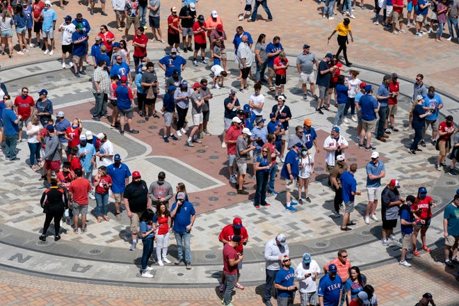 Fans line up to enter Globe Life Field before the Texas Rangers' home opener against the Toronto Blue Jays in Arlington, Texas. The Rangers are set to have the closest thing to a full stadium in pro sports since the coronavirus shutdown more than a year ago.