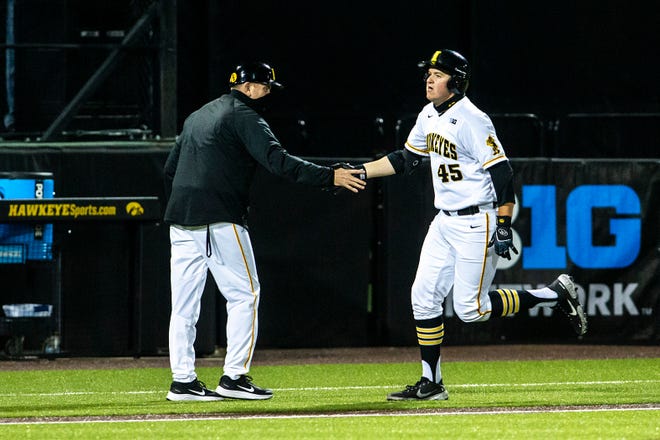 Iowa's Peyton Williams (45) celebrates with Iowa head coach Rick Heller after hitting a grand slam home run during a NCAA Big Ten Conference baseball game against Minnesota, Friday, April 9, 2021, at Duane Banks Field in Iowa City, Iowa.