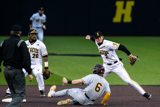 Iowa's Brendan Sher (2) finishes off a double play with Iowa's Izaya Fullard (20) as Minnesota's Chase Stanke (6) attempts to slide in to second during a NCAA Big Ten Conference baseball game, Friday, April 9, 2021, at Duane Banks Field in Iowa City, Iowa.