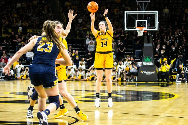 Iowa's McKenna Warnock (14) makes a 3-point basket during a NCAA Big Ten Conference women's basketball game against Michigan, Sunday, Feb. 27, 2022, at Carver-Hawkeye Arena in Iowa City, Iowa.
