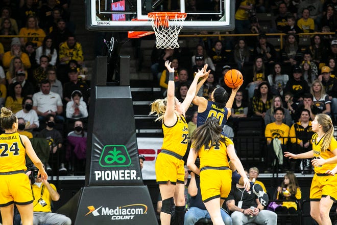 Michigan forward Naz Hillmon (00) shoots a basket as Iowa center Monika Czinano (25) defends during a NCAA Big Ten Conference women's basketball game, Sunday, Feb. 27, 2022, at Carver-Hawkeye Arena in Iowa City, Iowa.
