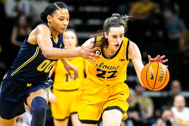 Iowa guard Caitlin Clark, right, gets a steal against Michigan forward Naz Hillmon during a NCAA Big Ten Conference women's basketball game, Sunday, Feb. 27, 2022, at Carver-Hawkeye Arena in Iowa City, Iowa.